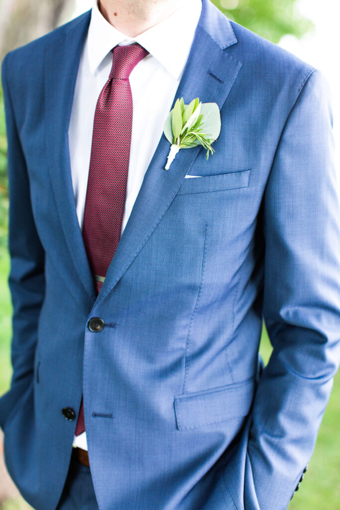 detail photo of groom's tie and boutonniere at elegant wedding at Red Crown Lodge