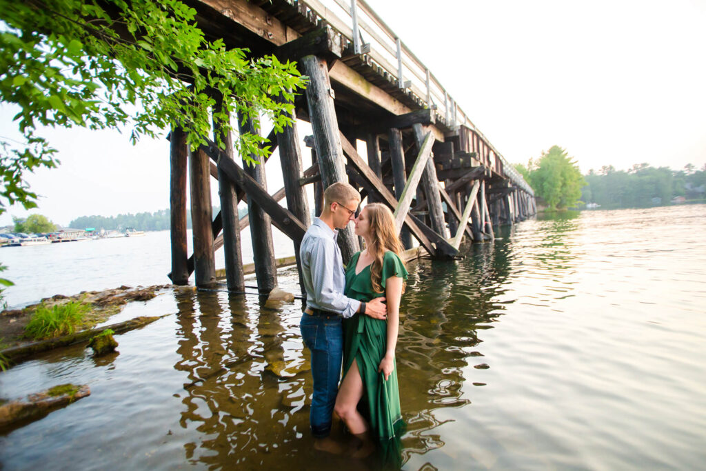 Romantic golden hour photo of couple in the water by Bearskin Trail Bridge over Minocqua Lake. Minocqua Family Session Tips
