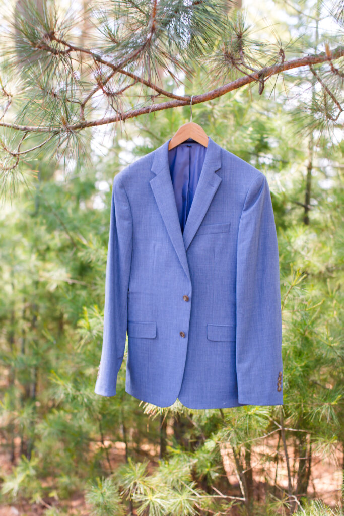 groom's suit jacket hanging on a branch at his Eagle River Cabin Wedding