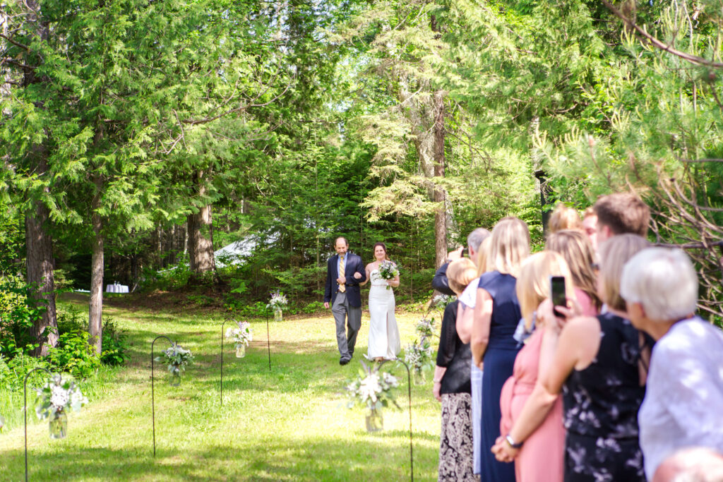 Bride coming down the aisle at Eagle River Cabin Wedding