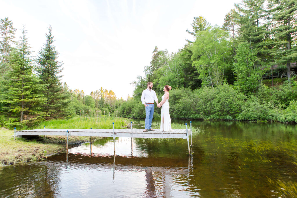Bride and groom on river dock at their Eagle River Cabin Wedding