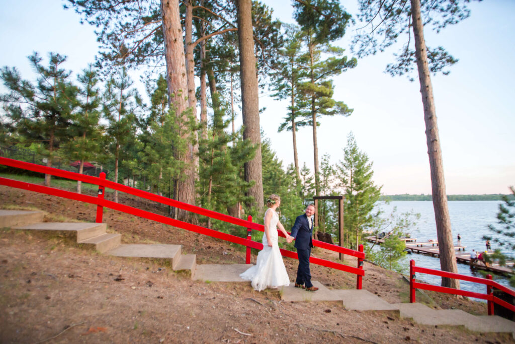 Bride & Groom walking hand in hand down the main stairs to the docks at eagle waters resort at sunset