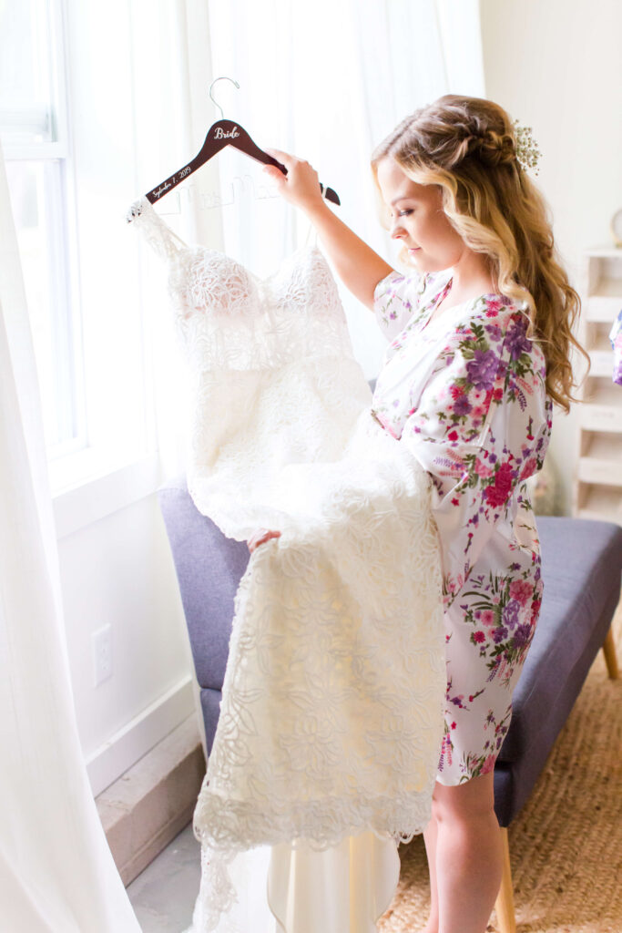 Bride holding her gown while getting ready at her summer wedding at farmin' betty's 